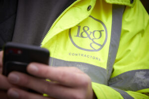 A close up of someone in a high visibility yellow jacket with an I&G logo