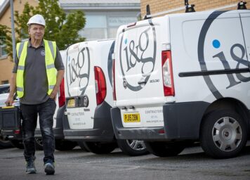 An I&G technician walks past some I&G branded vans